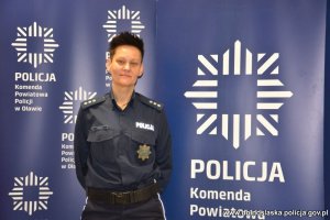 Na zdjęciu komisarz Agnieszka Borejko na tle baneru Komedy Powiatowej Policji w Oławie