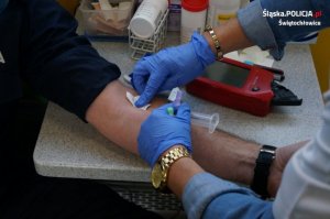 Na zdjęciu przedramię mundurowego podczas pobierania próbki krwi przez pracownicę RCiK w Katowicach