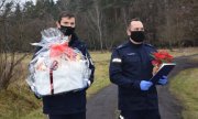 dwaj policjanci niosą prezenty dla kobiety