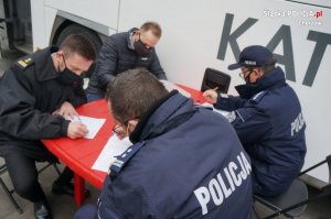 policjanci i strażak wypełniają dokumenty przed zdaniem krwii
