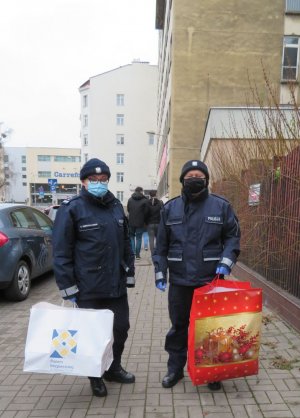 Policjanci z prezentami stoją przed rodzinnym domem dziecka w Warszawie.