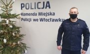 Dzielnicowy młodszy aspirant Peter Jonetzko stoi w budynku komendy policji, po lewej stronie stoi choinka świąteczna
