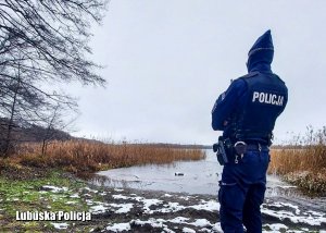 Policjant sprawdzający czy na zamarzniętym jeziorze nie ma osób