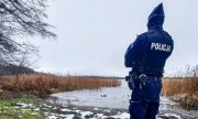 Policjant sprawdzający czy na zamarzniętym jeziorze nie ma osób