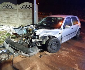 Zdjęcie rozbitego samochodu z tyłu stoją służby ratunkowe