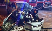 Zdjęcie rozbitego samochodu z tyłu stoją służby ratunkowe