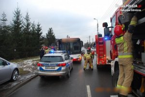 autobus, radiowóz policyjny, wóz strażacki oraz strażacy i policjanci pracujący na miejscu wypadku