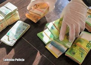 policjant układa pliki z pieniędzmi na stole