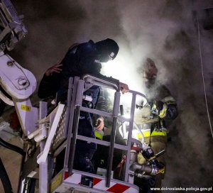 &quot;Policjant wraz ze strażakiem na koszu wysięgnika strażackiego pomagają w ewakuacji mężczyzny