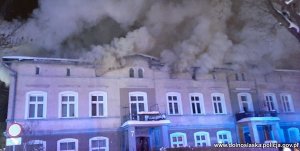 Płonący budynek wielorodzinny. Z okien wydobywają się kłęby dymu