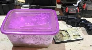 zabezpieczone narkotyki w plastikowym pojemniku oraz broń