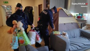 zdjęcie kolorowe: policjanci wnoszący pakunki do sali zabaw&quot;&gt;