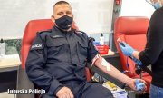 Policjant oddaje krew w krwiobusie.&quot;&gt;