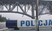 Napis Policja na dachu policyjnej łodzi, w tle widoczny fragment mostu