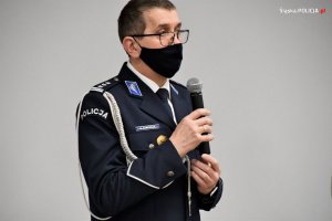 Umundurowany policjant - Komendant Wojewódzki Policji w Katowicach, trzyma w ręce mikrofon