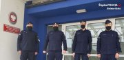 czterej umundurowani policjanci stoją przed wejściem do budynku, w którym stacjonuje Samodzielny Pododdział Prewencji Policji w Bielsku-Białej