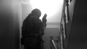 Policjant z Samodzielnego Pododdziału Kontrterrorystycznego Policji wchodzi po schodach w ręku trzyma broń