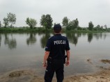 umundurowany policjant nad brzegiem wody