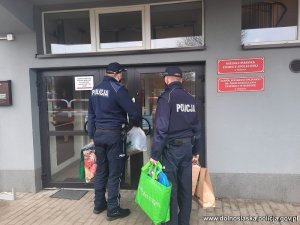 policjanci z torbami z zakupami wchodzą do MOPSu