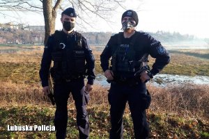 dwóch policjantów stoi w rejonie rzeki