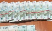 porozkładane pliki banknotów o nominałach 500 zł, 200 zł i 100 zł spięte  gumką