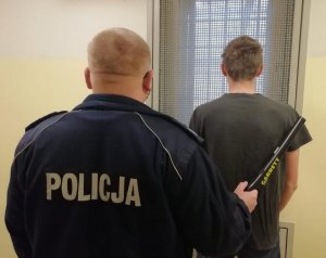 zatrzymany mężczyzna i policjant - widok z tyłu
