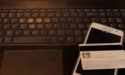 karta płatnicza i telefon komórkowy leżące na klawiaturze komputera