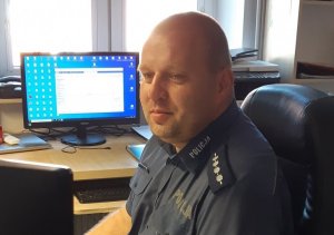 policjant w mundurze przy monitorze komputera wewnątrz budynku&quot;&gt;