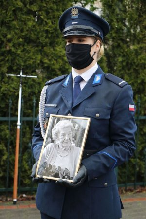 Policjantka trzymająca zdjęcie zmarłej Marii Czernek.