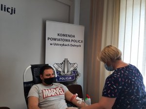 mężczyzna oddaje krew, przy nim stoi pielęgniarka