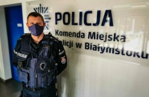 policjant w środku budynku z założoną maseczką na ustach i nosie
