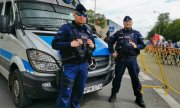 dwóch umundurowanych policjantów z Oddziału Prewencji Policji w Białymstoku, którzy stoją przed radiowozem