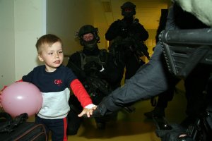 Dziecko przybijające &quot;piątkę&quot; z policjantami.