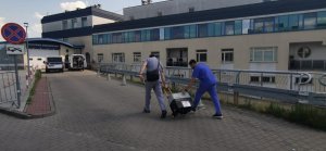 Medycy transportują pojemnik z sercem do budynku szpitala