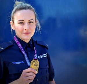 umundurowana policjantka trzyma w reku medal
