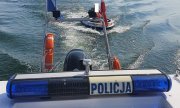 policyjna motorówka holuje łódź z dwoma osobami
