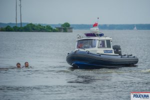 Łódź Policyjna i dwóch mężczyzn w wodzie