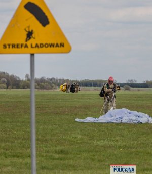 funkcjonariusze &amp;quot;BOA&amp;quot; po lądowaniu ze spadochronem, na pierwszym planie znak z napisem strefa lądowań