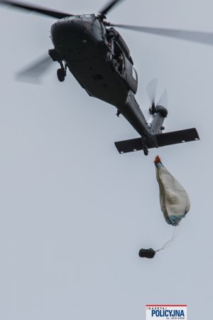 zrzut ładunku na spadochronie z policyjnego śmigłowca