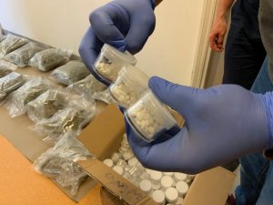 policjant trzyma woreczek z zabezpieczonymi narkotykami