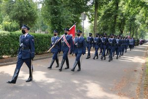 Policjanci kompanii reprezentacyjnej Policji prowadzą kondukt pogrzebowy