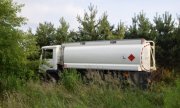 biała ciężarowa cysterna zaparkowana w zaroślach