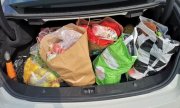 w bagażniku samochodowym torba plastikowa z zakupami  w postaci artykułów spożywczych