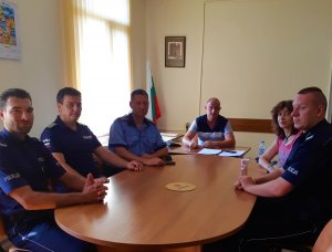 polscy i bułgarscy policjanci siedzą przy owalnym stole