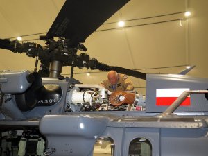 Policyjny mechanik lotniczy dokonuje przeglądu przed lotem silnika śmigłowca S70i Black Hawk.