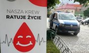 Plakat Klubu HDK PCK „Strażak” przy OSP w Łęczycy z napisem „Nasza krew ratuje życie. Dołącz do nas zostań honorowym dawcą krwi”. Na drugim planie znajduje się oznakowany radiowóz policyjny.&quot;