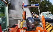 policyjna łódź tworzy strumień wody gaszący płonącą łódź