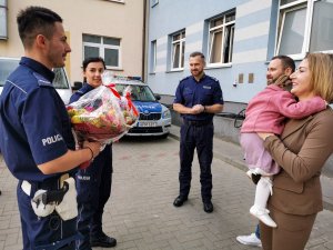 policjant i policjantka z prezentami, matka z dzieckiem na rękach i policjant