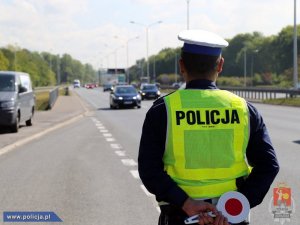 policjant ruchu drogowego stoi przy drodze podczas kontroli drogowej