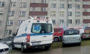 ambulans policyjnych medyków stoi przed blokiem mieszkalnym